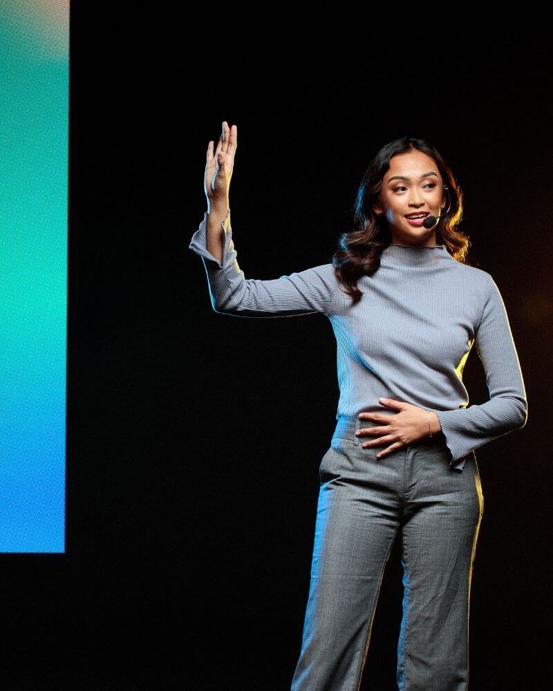 Moderatorin spricht auf einer Bühne