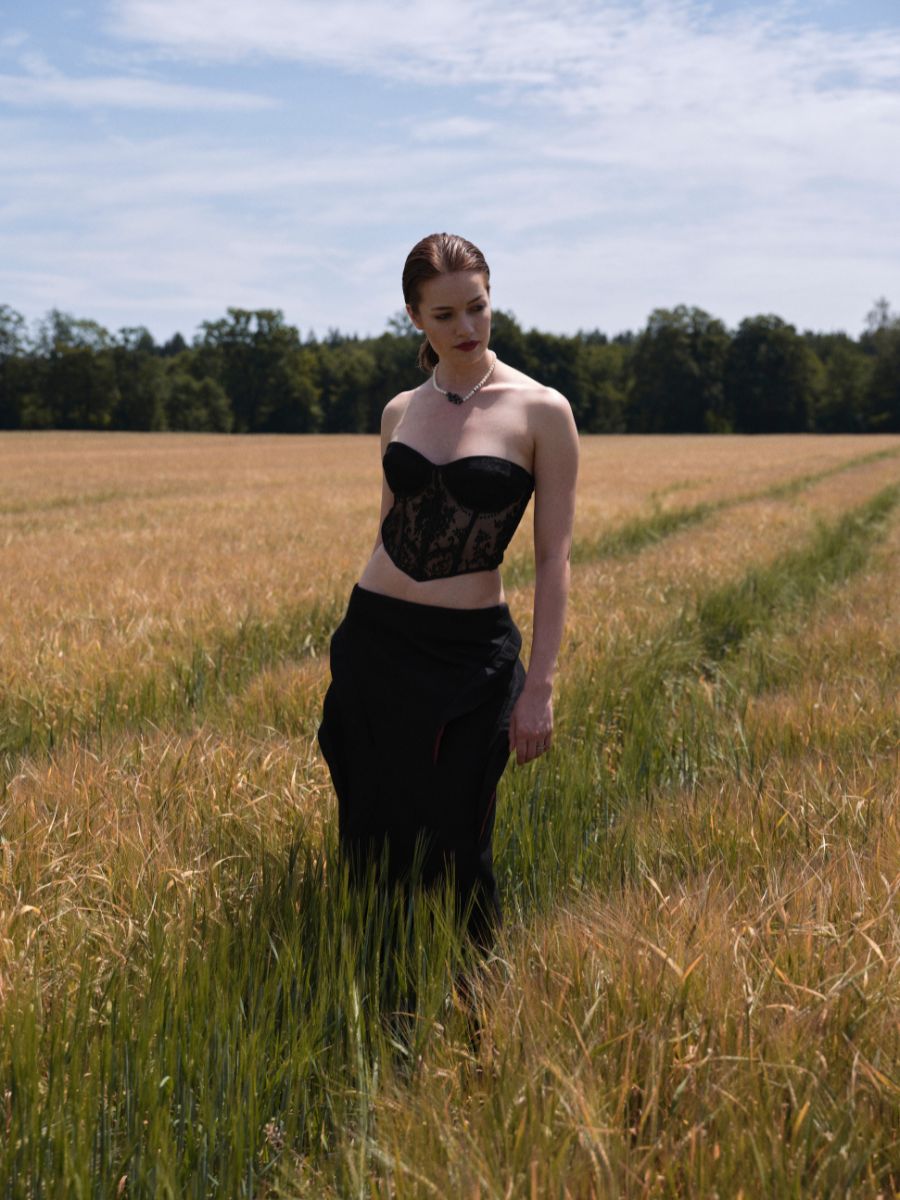 Frau im schwarzen Kleid mit Corsage im Kornfeld – Hair & Make-up Styling für FOGS Magazin