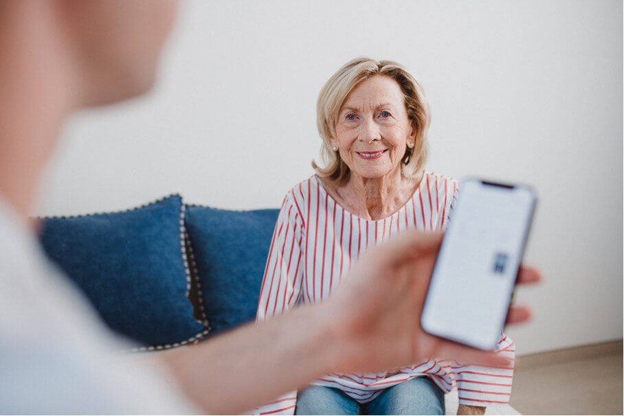 LINDERA Kampagne – Pfleger mit Smartphone bei Anwendung der Gesundheits-App, Haarstyling und Maske von Julia Ebert.