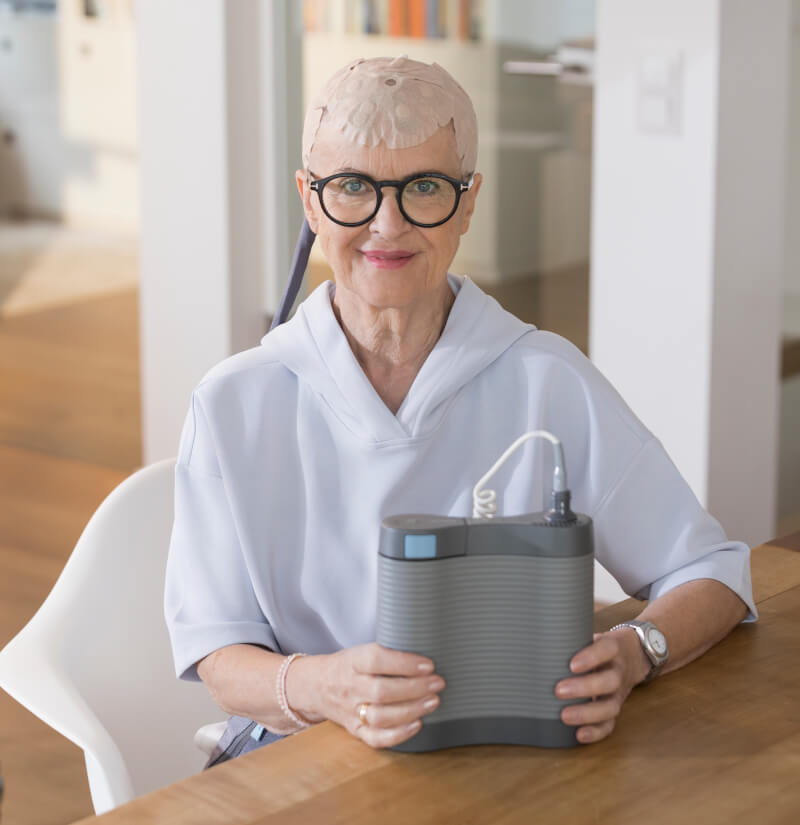 Patientin mit medizinischem Gerät im Novocure HealthCare-Shooting – Hair & Make-up Styling von Julia Ebert, München.